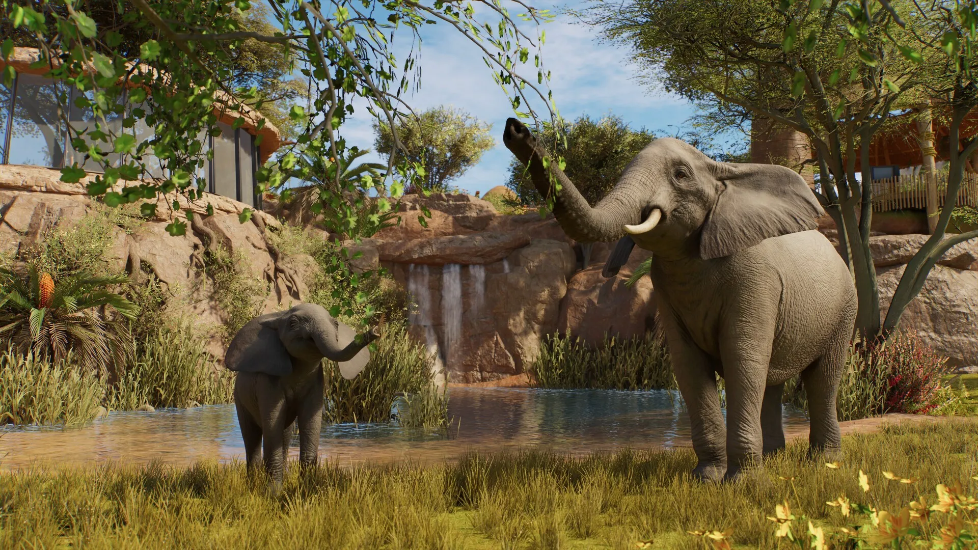 Una elefanta y su cría junto a un estanque, en un recinto de Planet Zoo 2