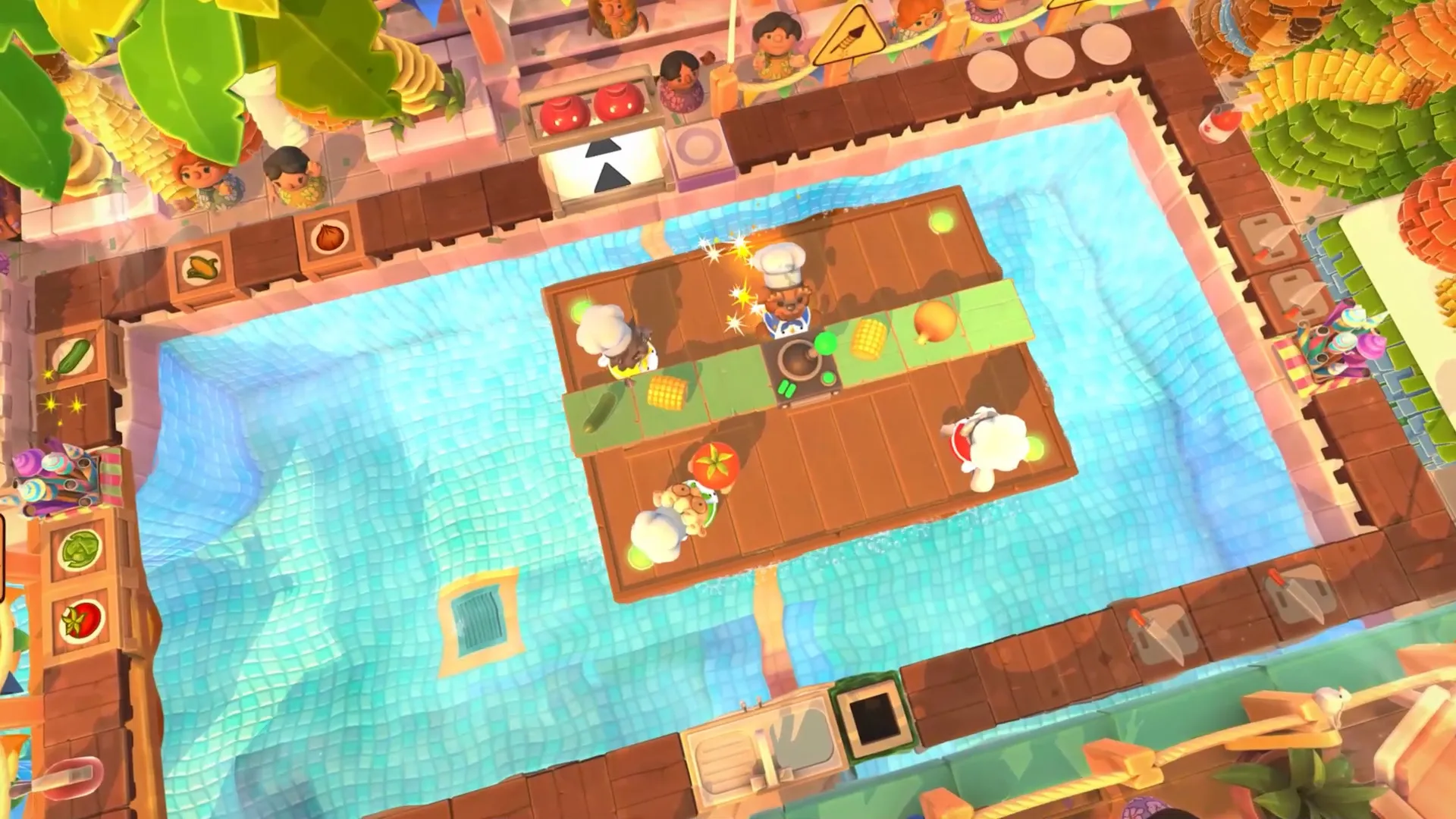 Vista desde arriba de una cocina sobre una piscina, con cocineros que corren entre mesas de ingredientes